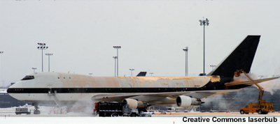 Jumbo jet is deiced on a runway at airport.