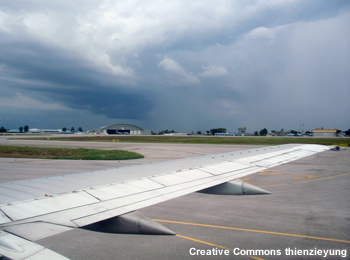 View out airplane window of wing as plane is landing.