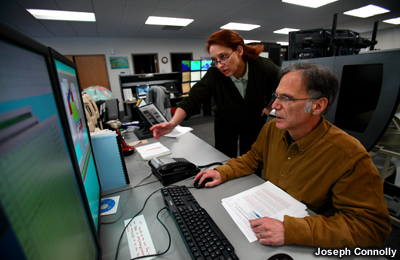 Dos científicos de turno consultan un monitor en el Centro de Alerta de Tsunami de Palmer, Alaska.
