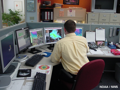 Pronosticador que examina los datos en una estación de trabajo AWIPS