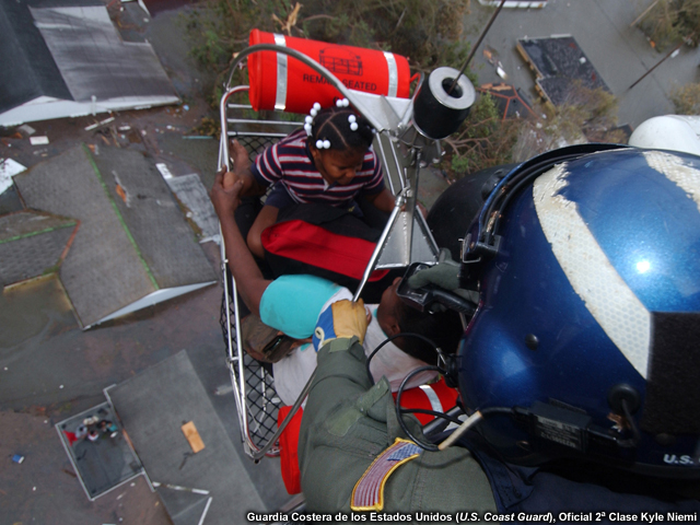 Un helicóptero de la guardia costera de EE.UU rescata a dos víctimas de las aguas de Huracán Katrina.