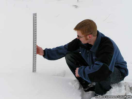 Un observador mide la profundidad total de la capa de nieve.