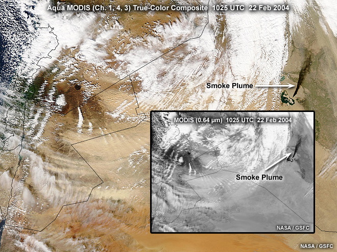 Aqua MODIS true-color composite image showing a black smoke plume from an oil fire blowing dust and cloud cover over Northern Iraq, taken at 1025 UTC on February 22, 2004.
