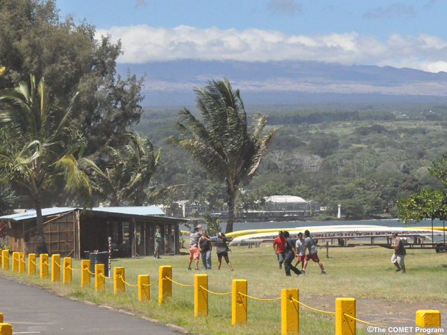 photo of people running in park area with harbor at Hilo visible in background