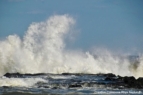 photo of wave crashing against rocks