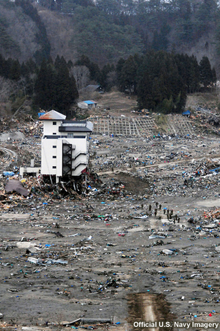 photo of tsunami damage in Japan following March 2011 earthquake and tsunami. bottom floors of multistory building have been washed away by waves.