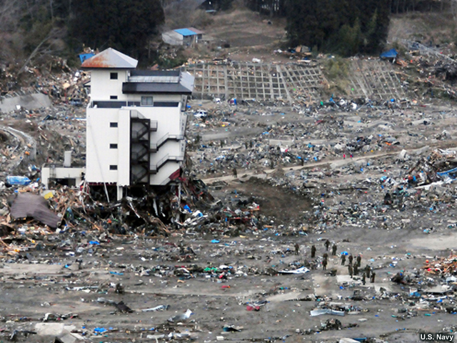 WAKUYA, Japan (March 15, 2011) A Japanese search and rescue team searches the rubble near a high-rise building in Wakuya, Japan after a 9.0 magnitude earthquake and subsequent tsunami devastated the area. Ships and aircraft from the Ronald Reagan Carrier Strike Group are conducting search and rescue operations and re-supply missions as directed in support of Operation Tomodachi throughout northern Japan. (U.S. Navy photo by Mass Communication Specialist 3rd Class Alexander Tidd/Released)