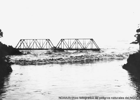 A tsunami bore, or sheer stepped wave, rolls into the Wailuku River during the 1946 tsunami in Hawaii.