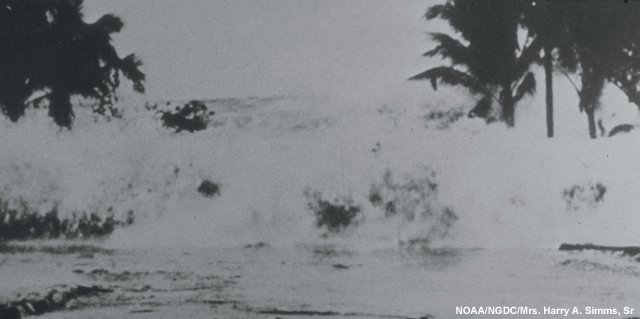 Tsunami striking the beachfront in an area east of Hilo following the 1946 earthquake in the Aleutians.